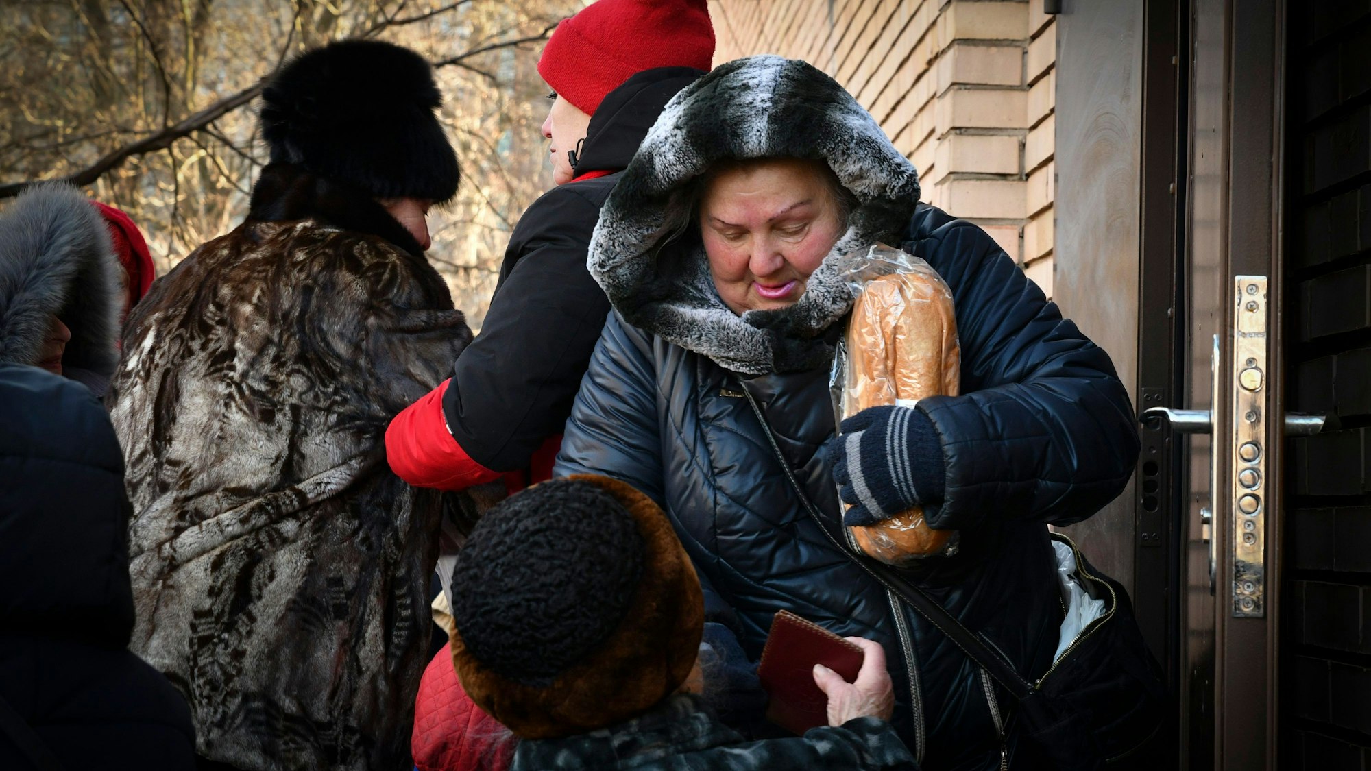 Eine Frau hält an einer Ausgabestelle für humanitäre Hilfe in Kramatorsk einen Laib Brot.