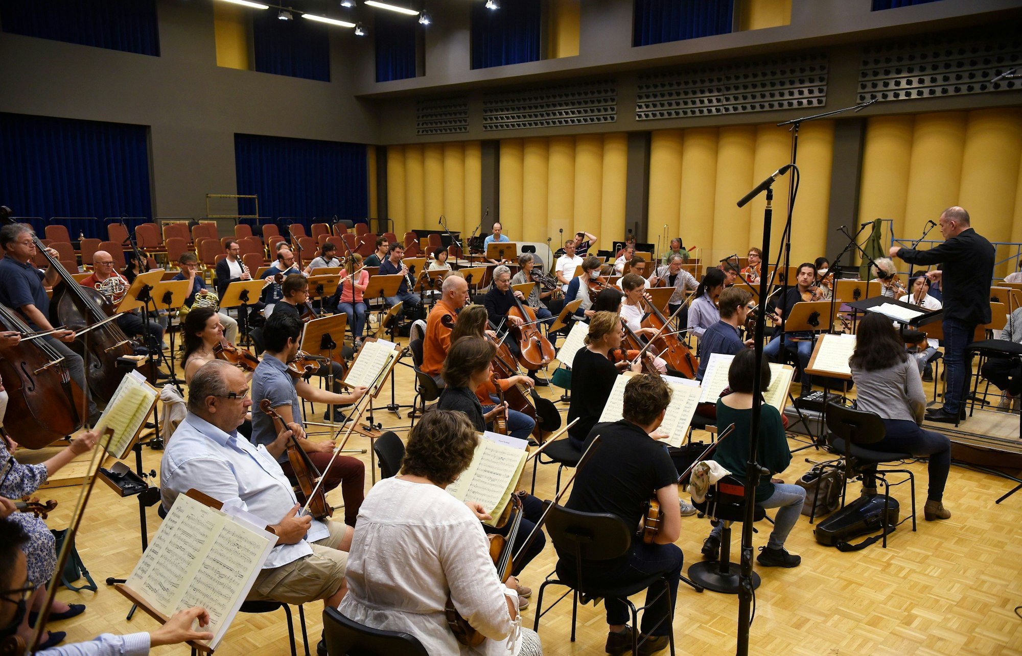 Viele Musiker des Gürzenich-Orchesters sitzen in einem Raum und proben.