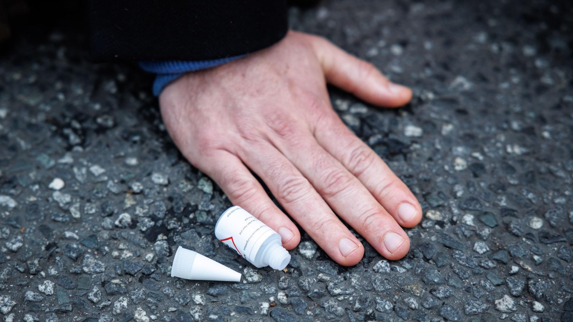 Ein Aktivist der Klimaschutz-Initiative·„Letzte Generation“ hat sich am Stachus mit seiner Hand auf die Straße geklebt.