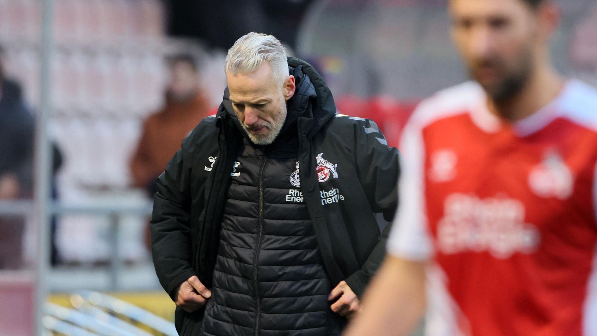 Ein Fußballtrainer verlässt mit enttäuschter Miene den Platz.