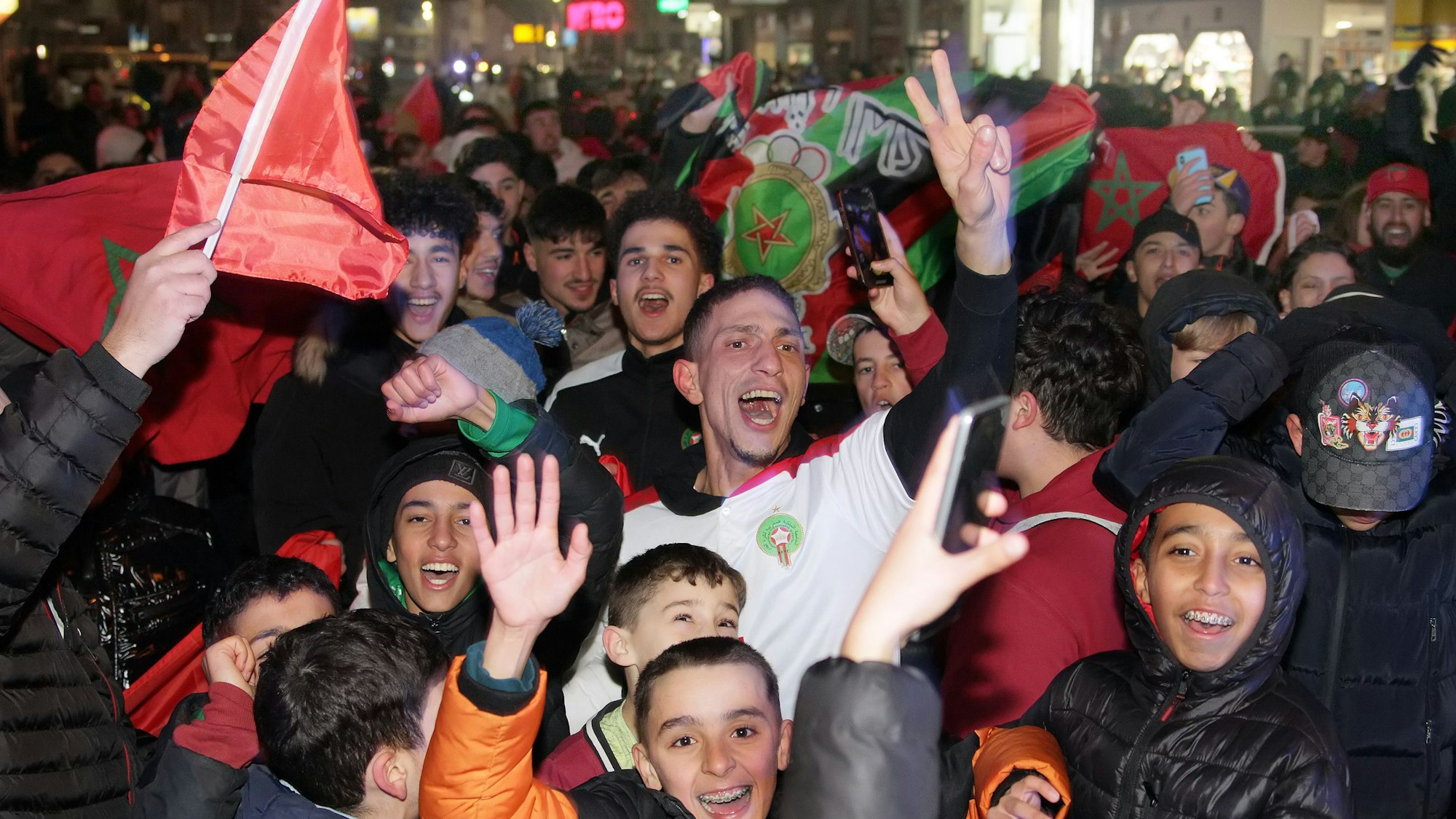 Das Bild zeigt zahlreiche Marokkaner auf der Straße in Bergheim, die den Sieg ihrer Mannschaft friedlich feiern.