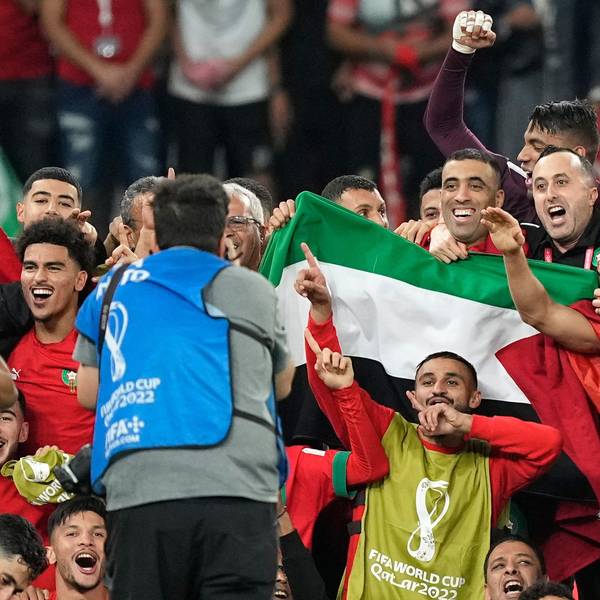 Marokkos Mannschaft posiert nach dem Sieg über Portugal für ein Gruppenfoto auf dem Spielfeld mit einer palästinensischen Flagge.