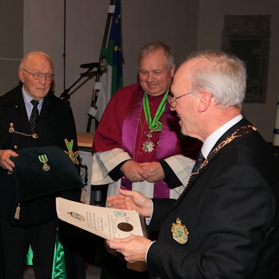 Das Bild zeigt die Übergabe der Urkunde zum Verdienstorden überreicht von Großprior Dr. Rudolf Wansleben an Dr. Bernhard Worms. Im Hintergrund Klaus-Peter Pokolm und Generalkaplan Thorsten Neudenberger.