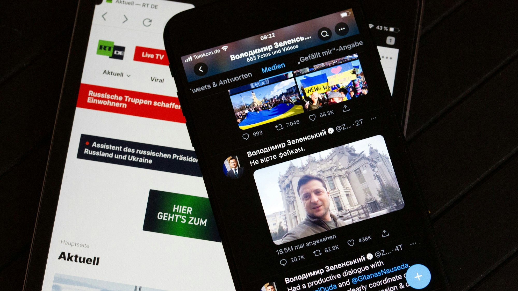 Auf dem Bildschirm eines Tablets (l) ist die Website des russischen Fernsehsenders RT zu sehen. Rechts ist auf dem Bildschirm eines Smartphones der offizieller Twitter-Account des ukrainischen Präsidenten Selenskyj zu sehen.