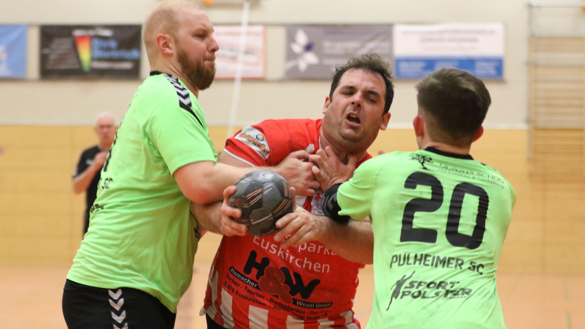 HSG-Handballer Niklas Müller wird von zwei Pulheimer Spielern in grellgrünen Trikots bedrängt.