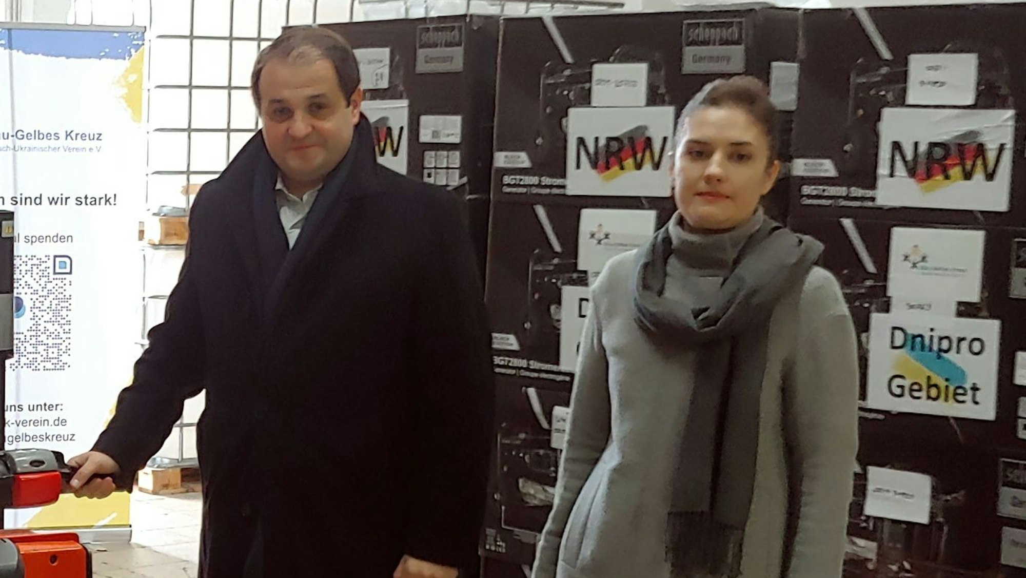 CDU-Landesminister Nathanael Liminski und Generalkonsulin Iryna Shum stehen im Lager des Blau-Gelben Kreuzes.