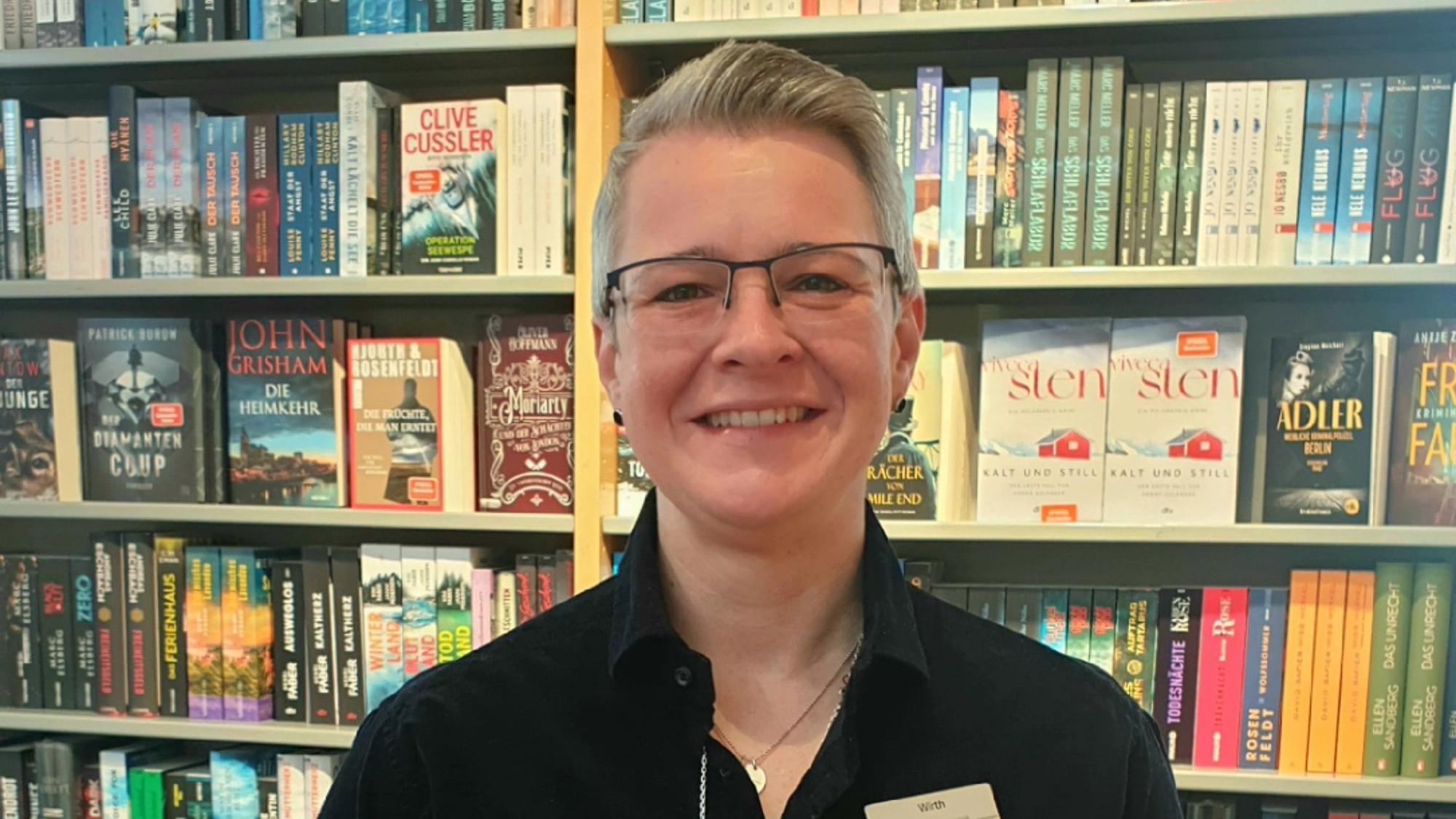 Stefanie Wirth steht vor einem Bücherregal in ihrer Buchhandlung.