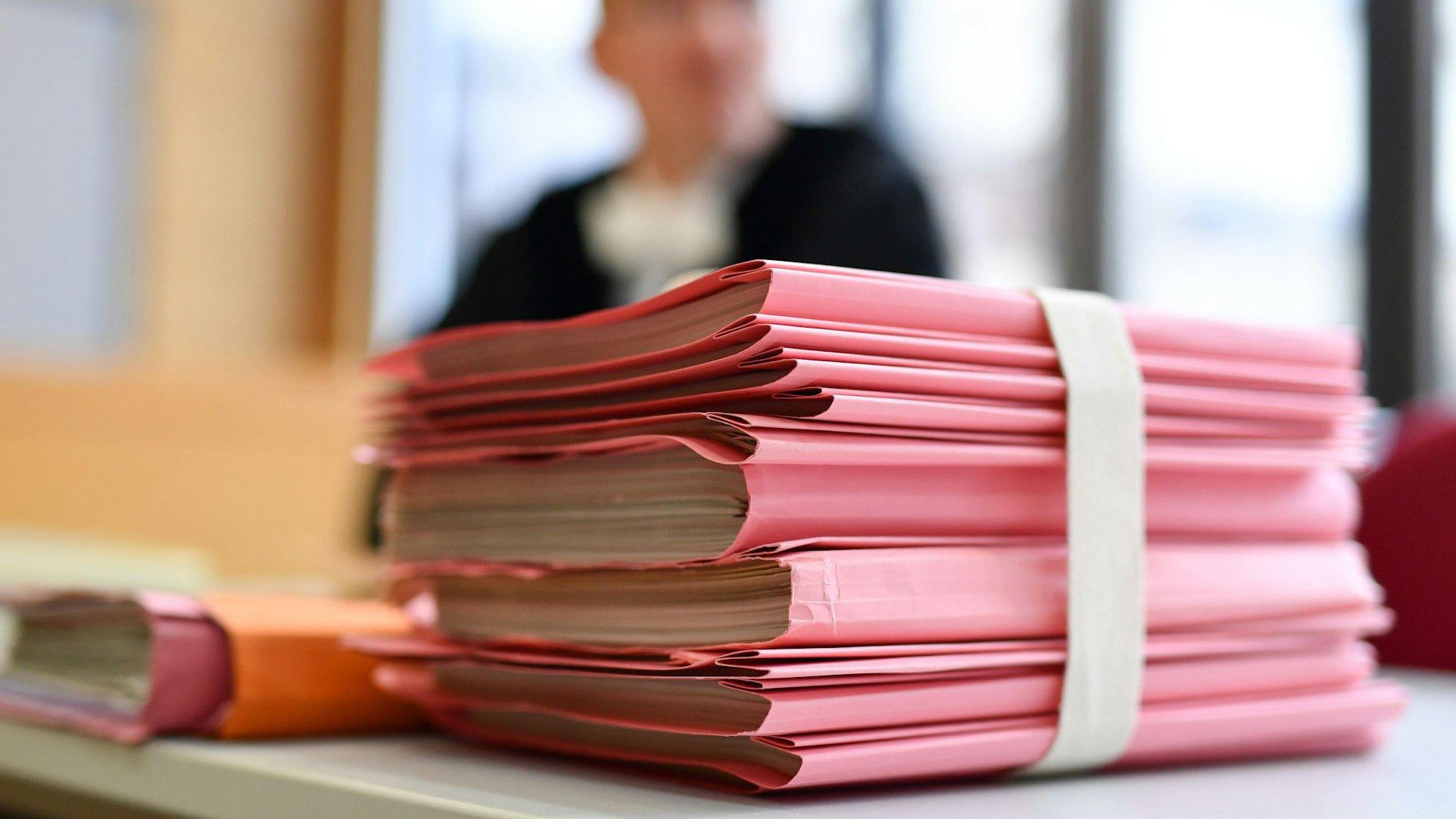 Ein Staatsanwalt sitzt im Landgericht hinter einem Stapel Akten.
