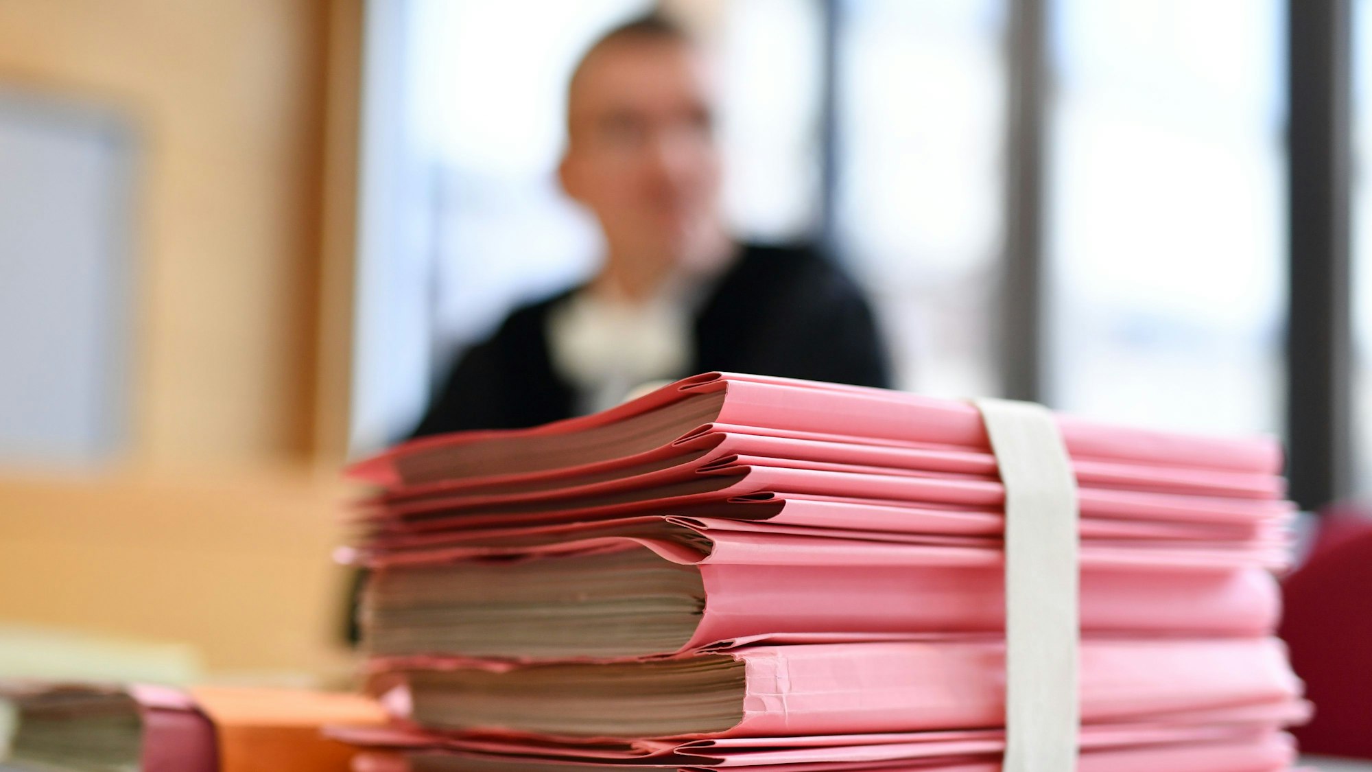 Ein Staatsanwalt sitzt im Landgericht hinter einem Stapel Akten.
