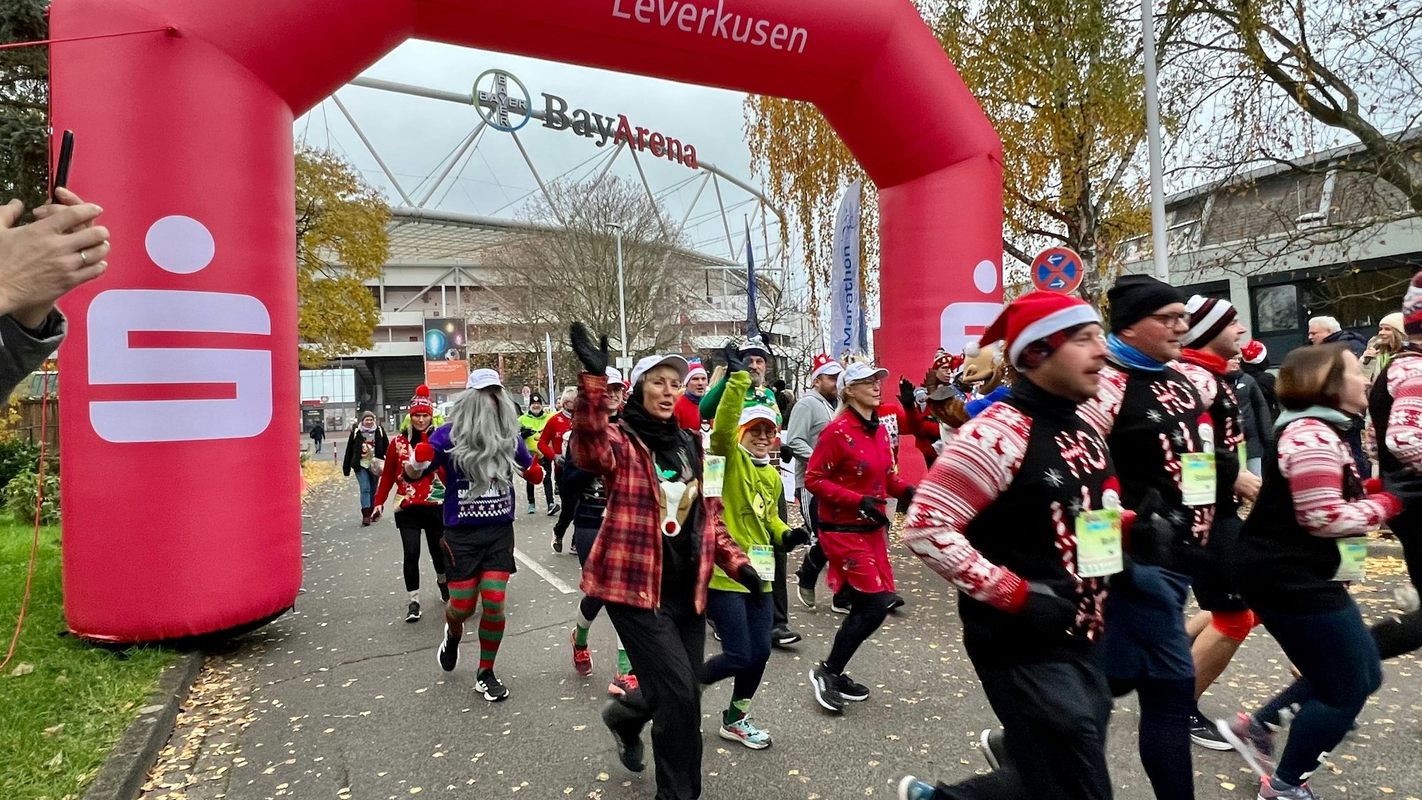Läufer in knallbunten Trikots am Start vor der BayArena
