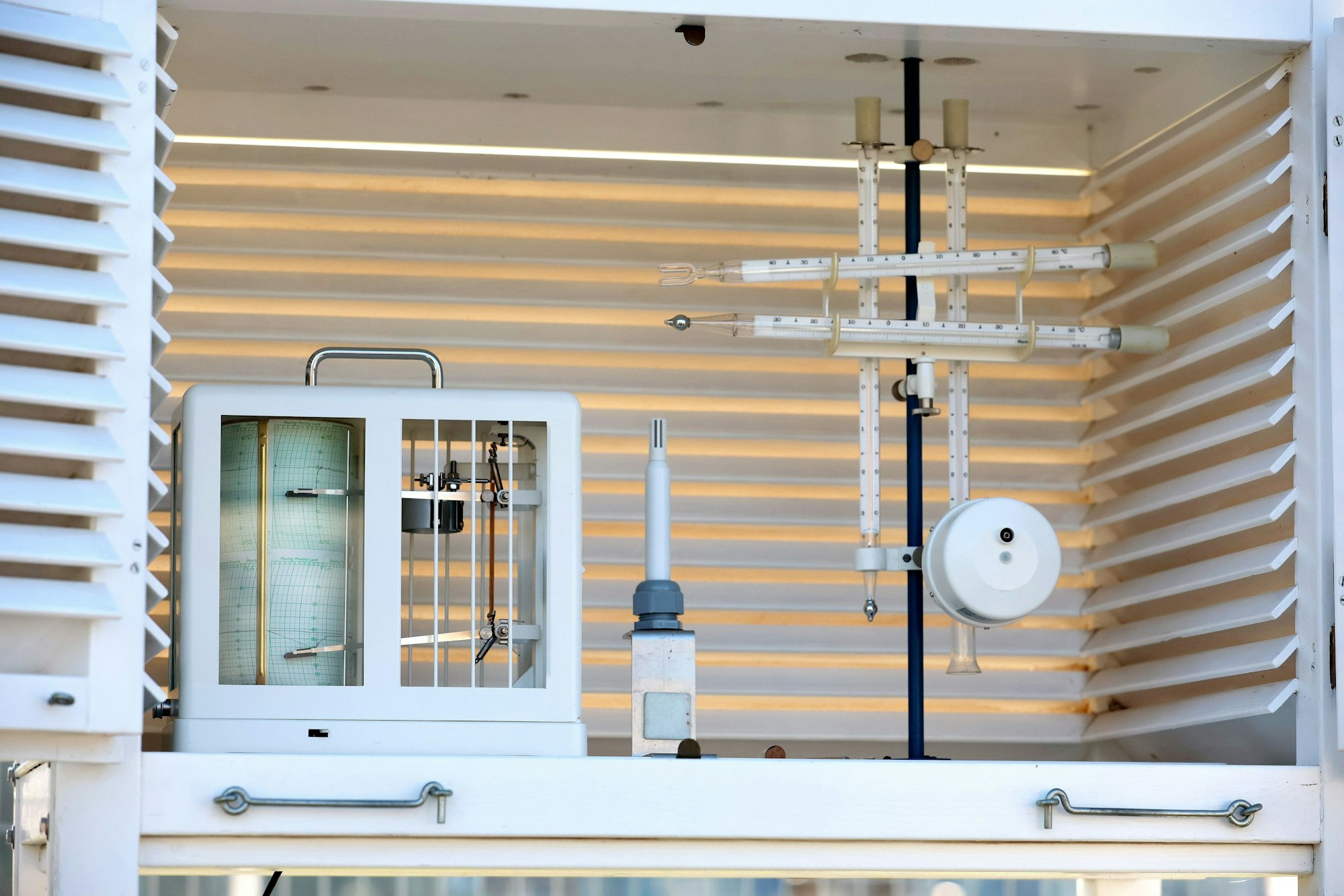 Wetterstation im Grüngürtel: Messgeräte sind in einem luftdurchlässigen weißen Kasten montiert.