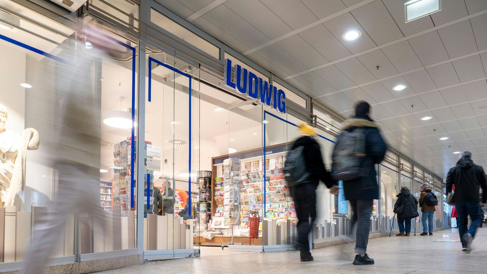 Menschen gehen am Schaufenster der neuen Buchhandlung Ludwig vorbei.