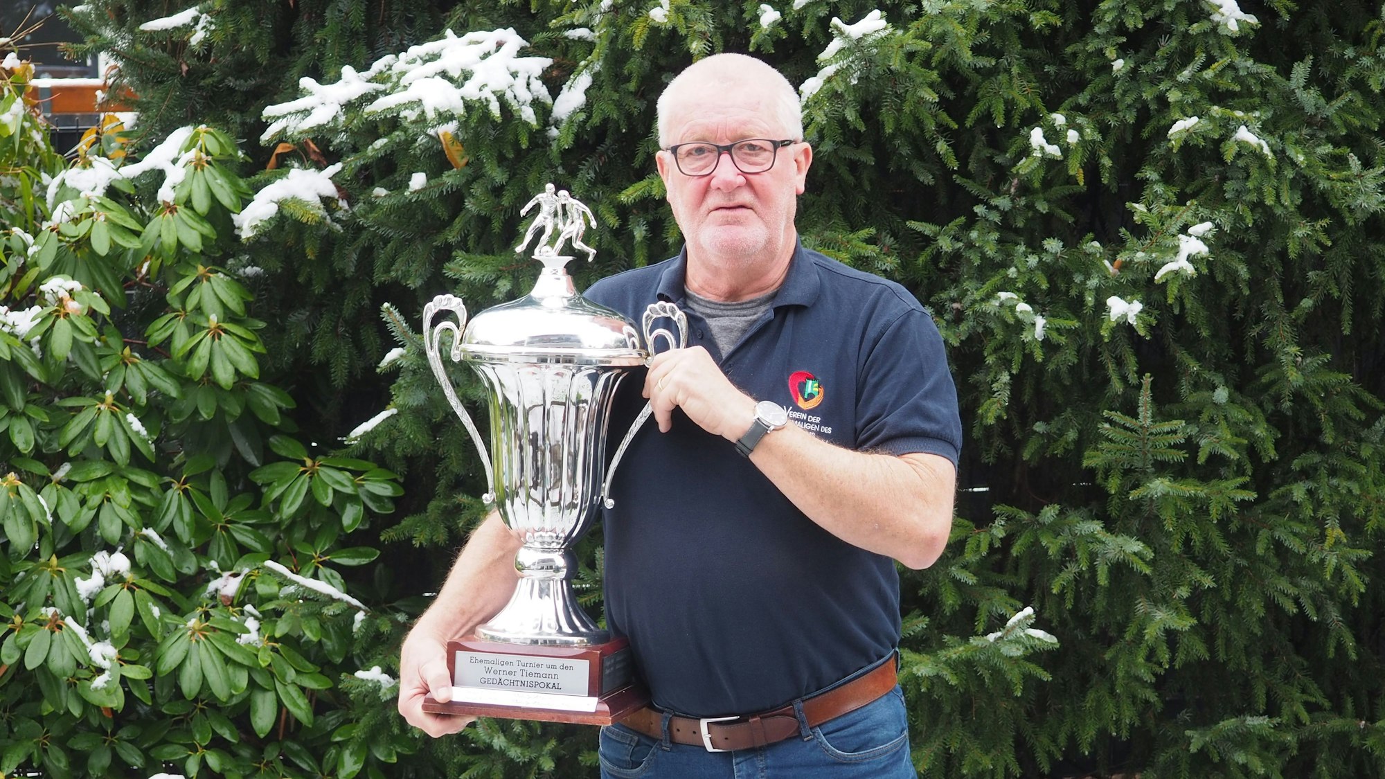 Folke Andräs hält den Pokal des Fußballturniers in den Händen