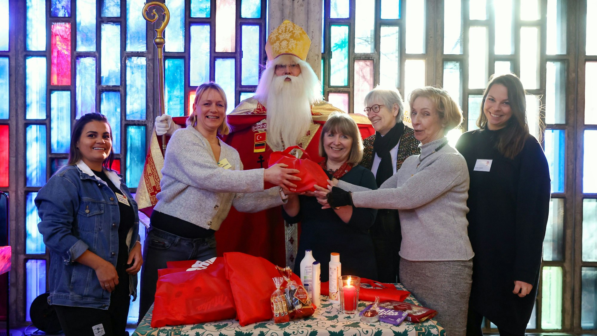 Weihnachtstüten fürs Gefängnis: Suelen und Vivien (Häftlinge), JVA-Direktorin Angela Wotzlaw und anderen stehen neben dem verkleideten Nikolaus.