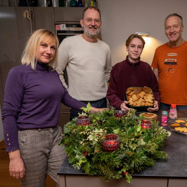 Svetlana Kiktieva und ihr Sohn Oleksij stehen zusammen mit ihren Gastgebern Michael Znamencek und Gert van der Kwartel vor einem Adventskranz und Plätzchen in der Küche.