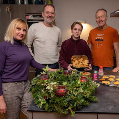 Svetlana Kiktieva und ihr Sohn Oleksij stehen zusammen mit ihren Gastgebern Michael Znamencek und Gert van der Kwartel vor einem Adventskranz und Plätzchen in der Küche.