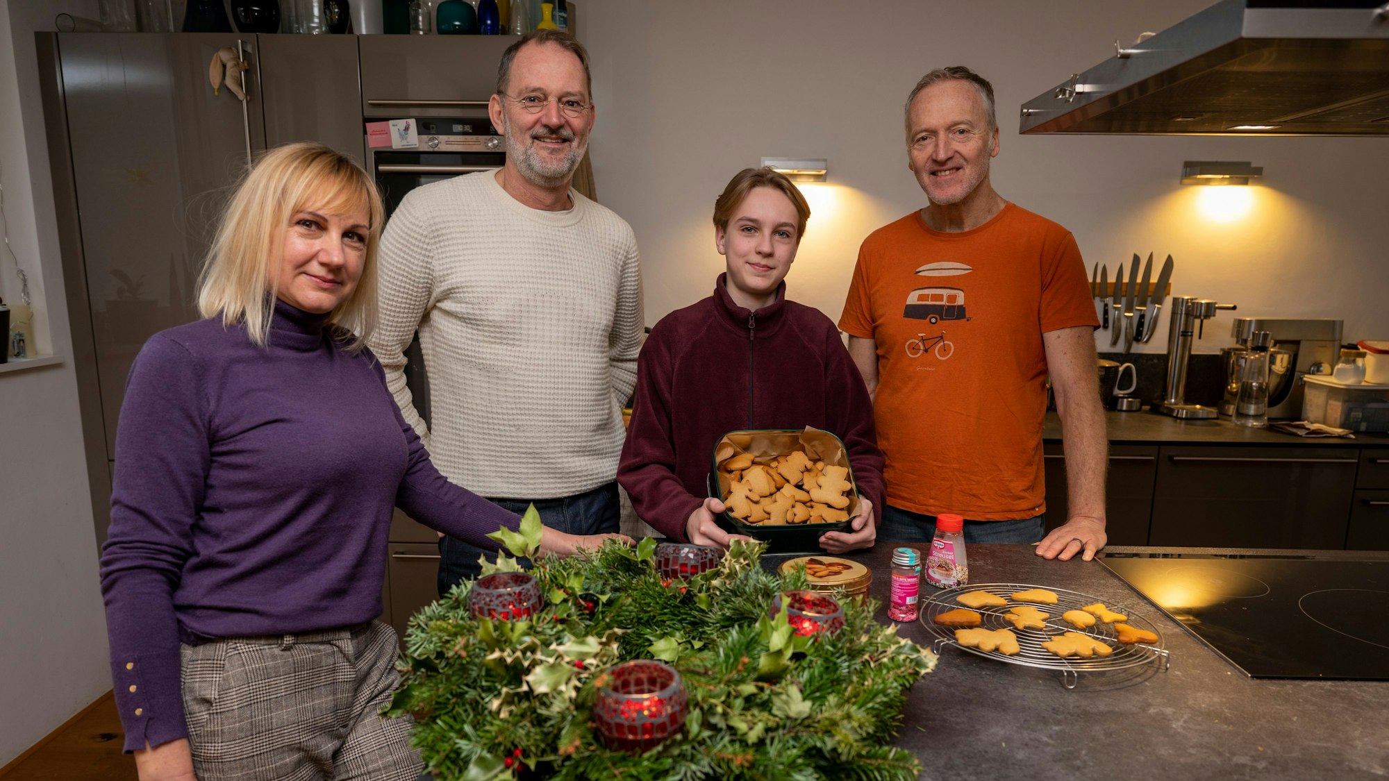 Svetlana Kiktieva und ihr Sohn Oleksij stehen zusammen mit ihren Gastgebern Michael Znamencek und Gert van der Kwartel vor einem Adventskranz und Plätzchen in der Küche.