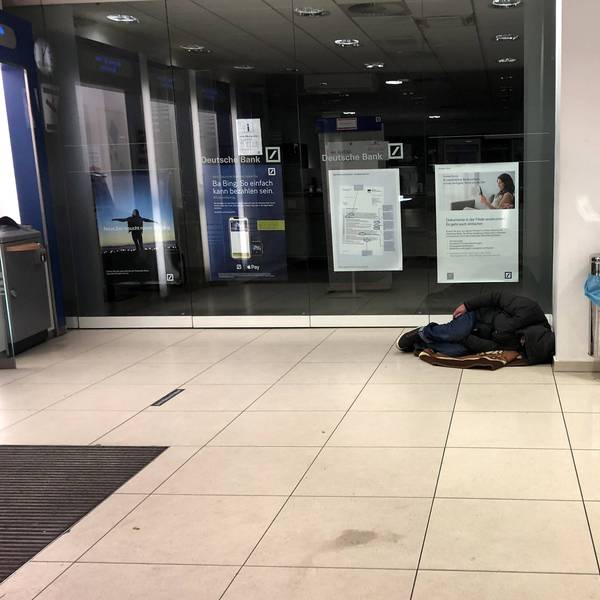 Ein Obdachloser schläft im Vorraum einer Filiale der Deutschen Bank in Köln (Symbolbild)
