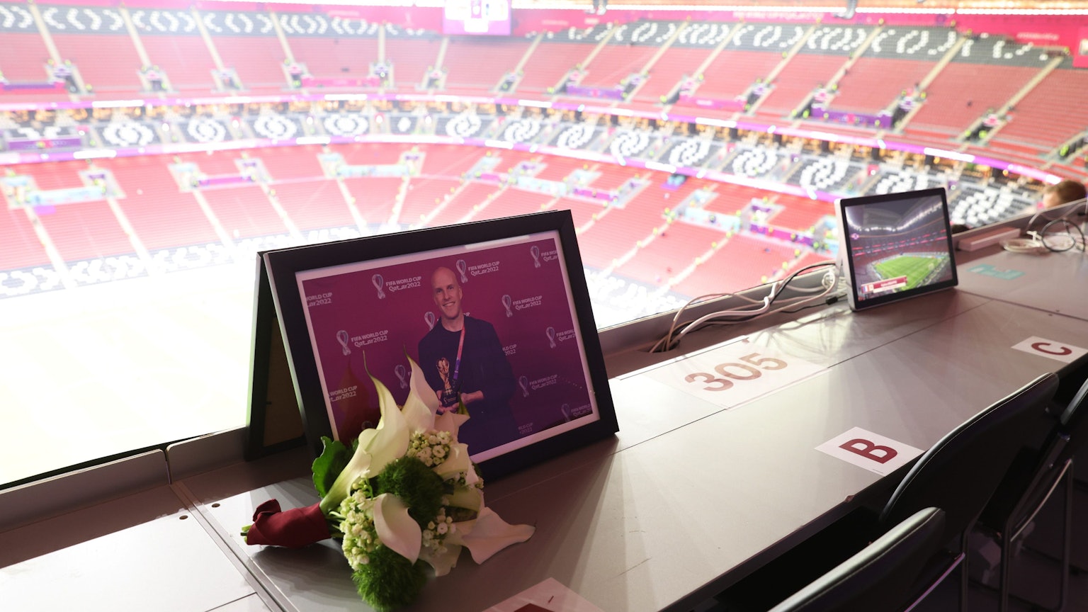 Auf der Tribüne liegen vor der Partie zwischen Frankreich und England Blumen für Grant Wahl an einem leeren Platz im Pressebereich.