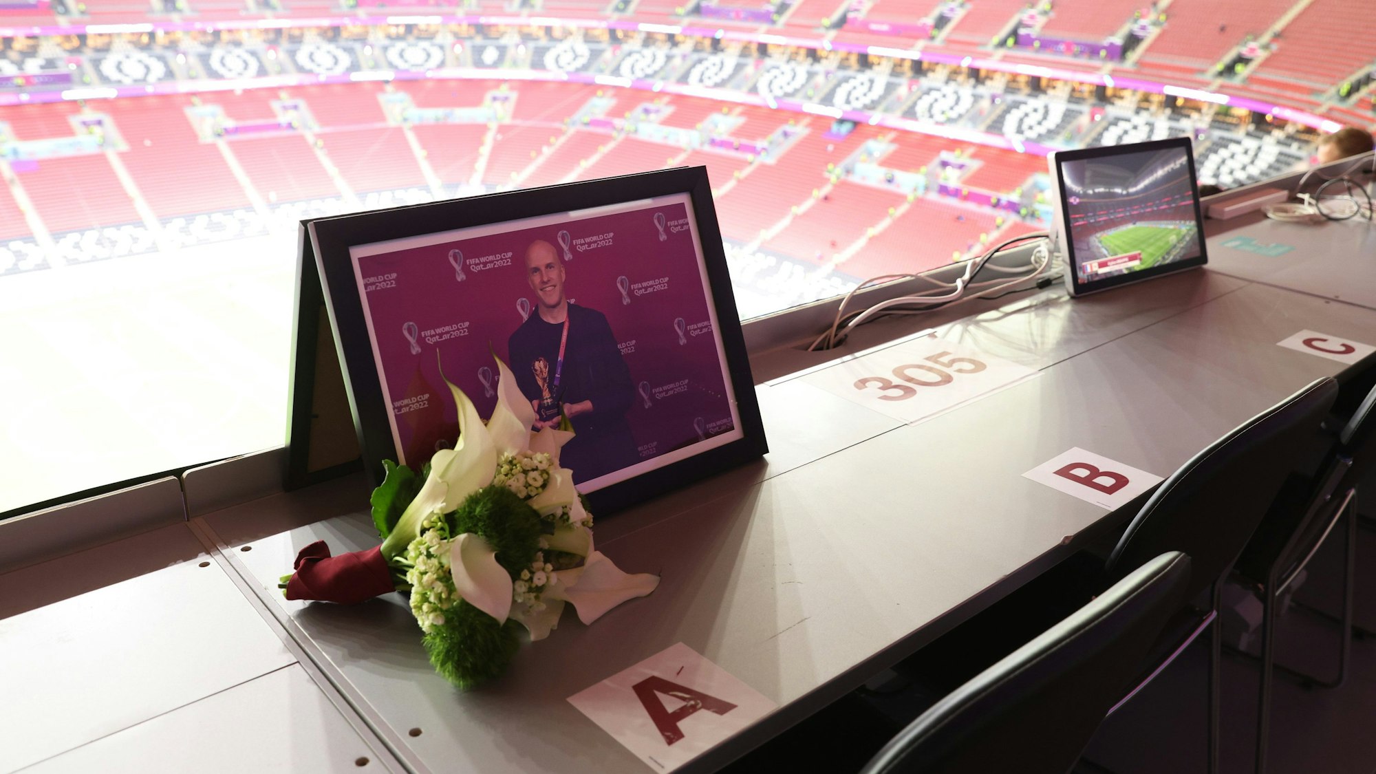 Auf der Tribüne liegen vor der Partie zwischen Frankreich und England Blumen für Grant Wahl an einem leeren Platz im Pressebereich.