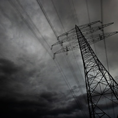 Hochspannungsleitungen vor finsterem Himmel