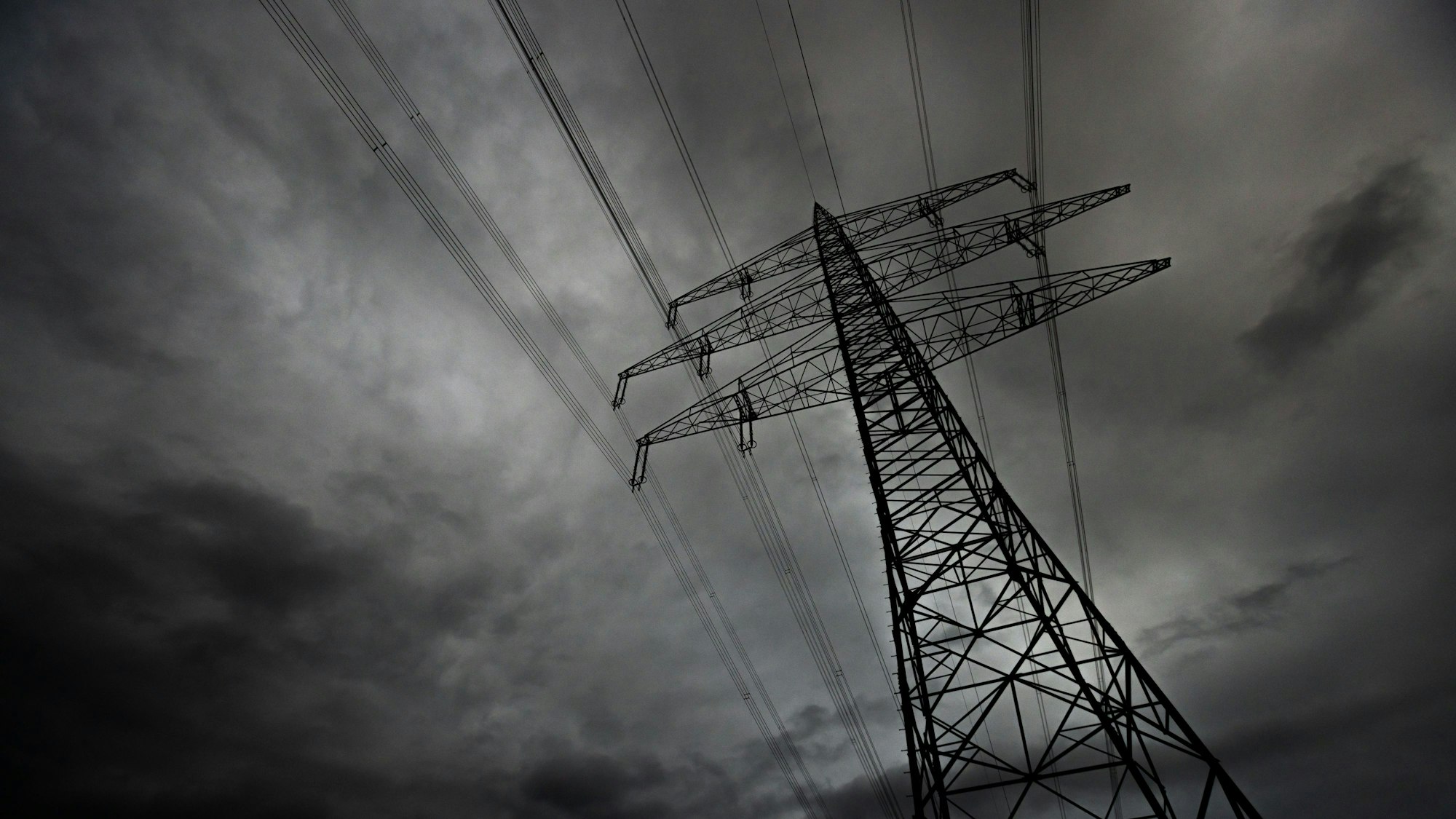 Hochspannungsleitungen vor finsterem Himmel