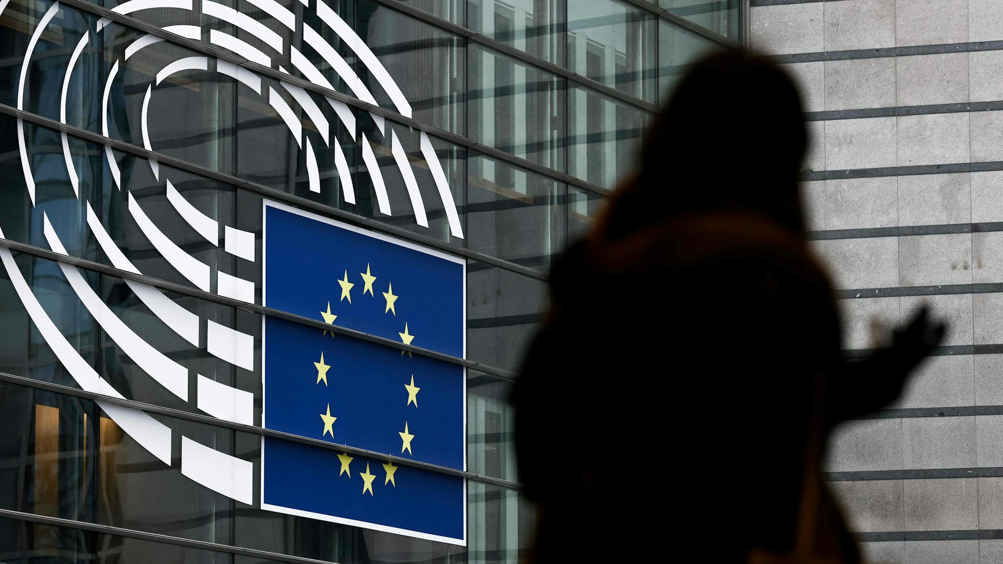 Eine Frau geht vor dem Europäischen Parlament in Brüssel her.