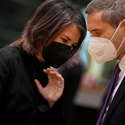 12.12.2022, Belgien, Brüssel: Die deutsche Außenministerin Annalena Baerbock (Grüne) (l) spricht mit einem Mitglied der Delegation während eines Treffens der EU-Außenminister im Gebäude des Europäischen Rates in Brüssel.