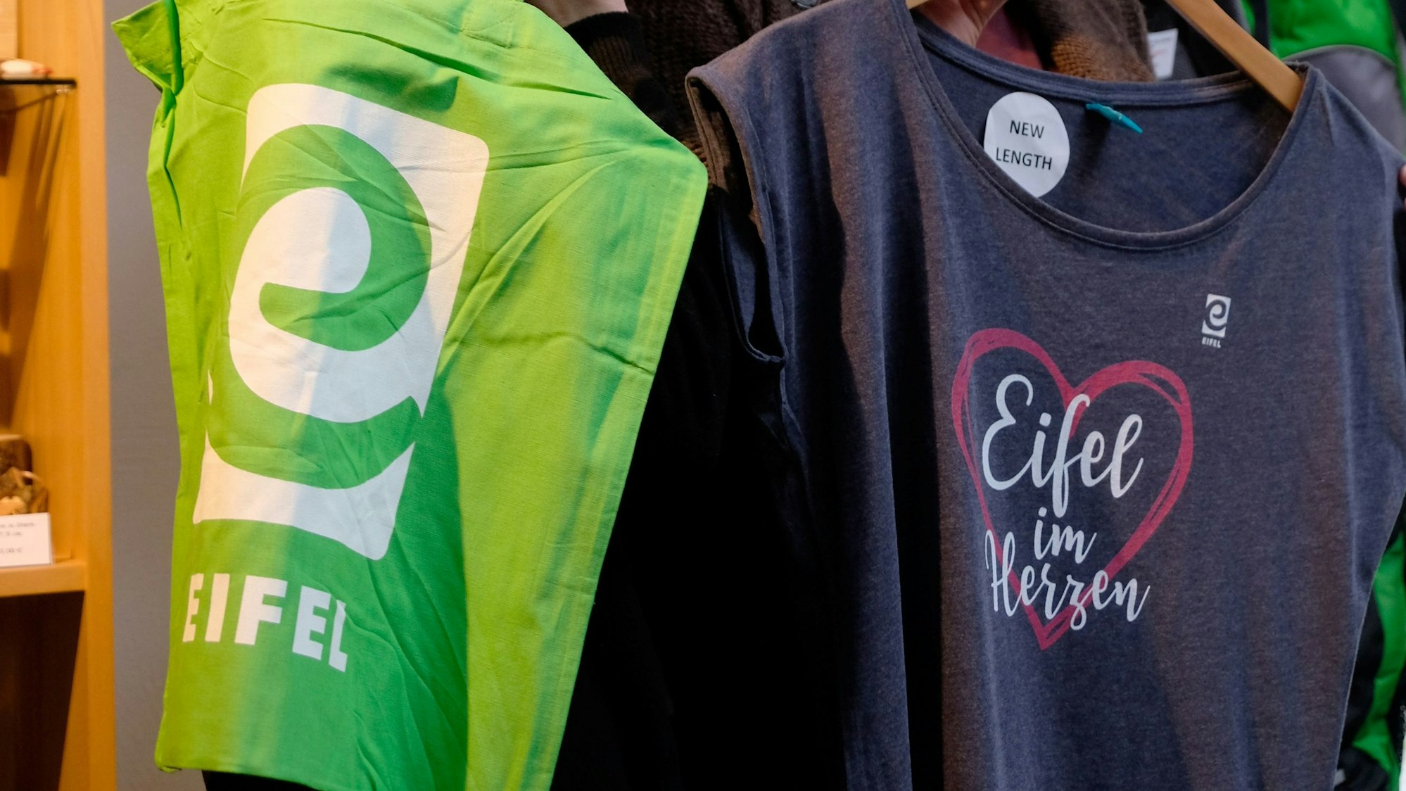 Lisa Frick und Doris Dohmen-Bach halten eine Stofftasche und ein T-Shirt in der Hand.