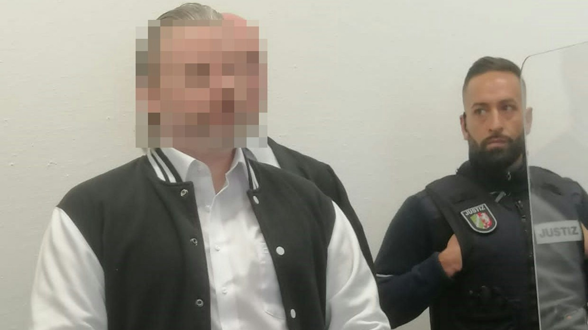 Der Angeklagte Martin B. steht neben einem Justizbeamten.