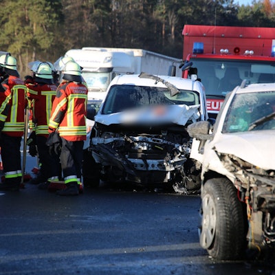 Bei einer Karambolage mit zwölf Fahrzeugen auf der Autobahn 9 in Oberfranken sind nach Angaben des Bayerischen Roten Kreuzes neun Menschen verletzt worden. Kaputte Autos und Rettungskräfte stehen auf der Fahrbahn.
