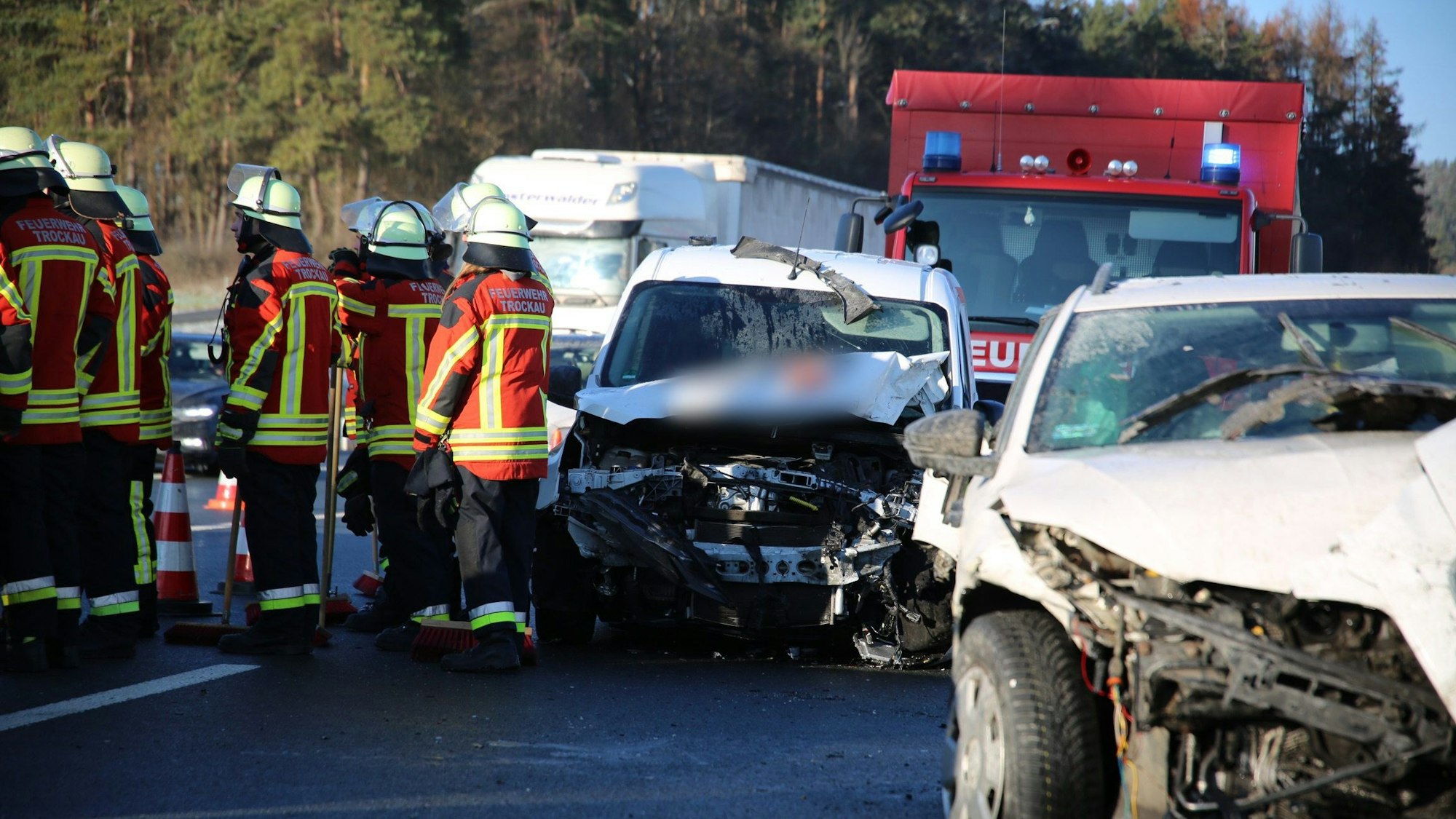 Bei einer Karambolage mit zwölf Fahrzeugen auf der Autobahn 9 in Oberfranken sind nach Angaben des Bayerischen Roten Kreuzes neun Menschen verletzt worden. Kaputte Autos und Rettungskräfte stehen auf der Fahrbahn.