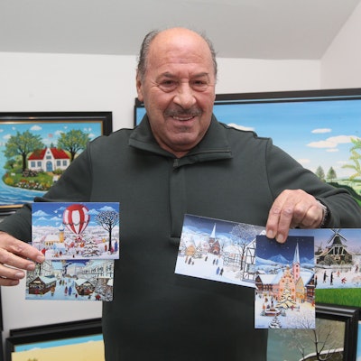 Der Troisdorfer Maler Josef Hawle hält seine fünf Motive für Unicef in der Hand.