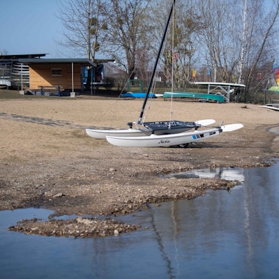 Ein Boot liegt auf dem Trockenen am Rand des Zülpicher Sees. Das Wasser ist zurückgegangen, sodass der Seeboden zu sehen ist.