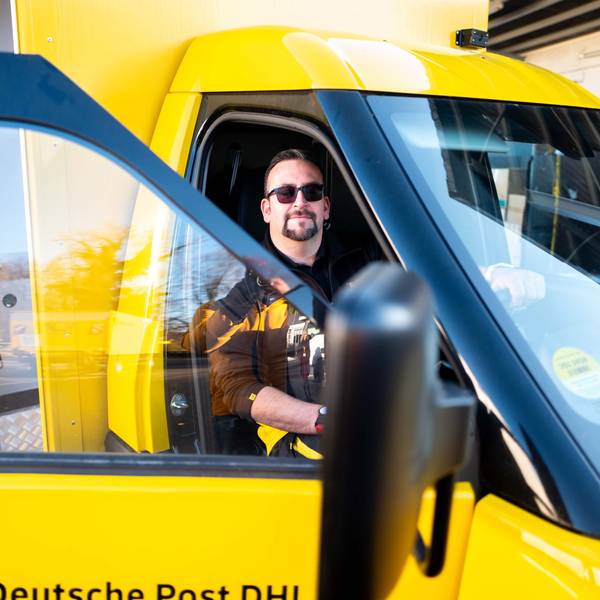 Zusteller Christoph Kompalka sitzt hinter dem Steuer des neuen Street-Scooter-Gigabox-Rechtslenkers.
