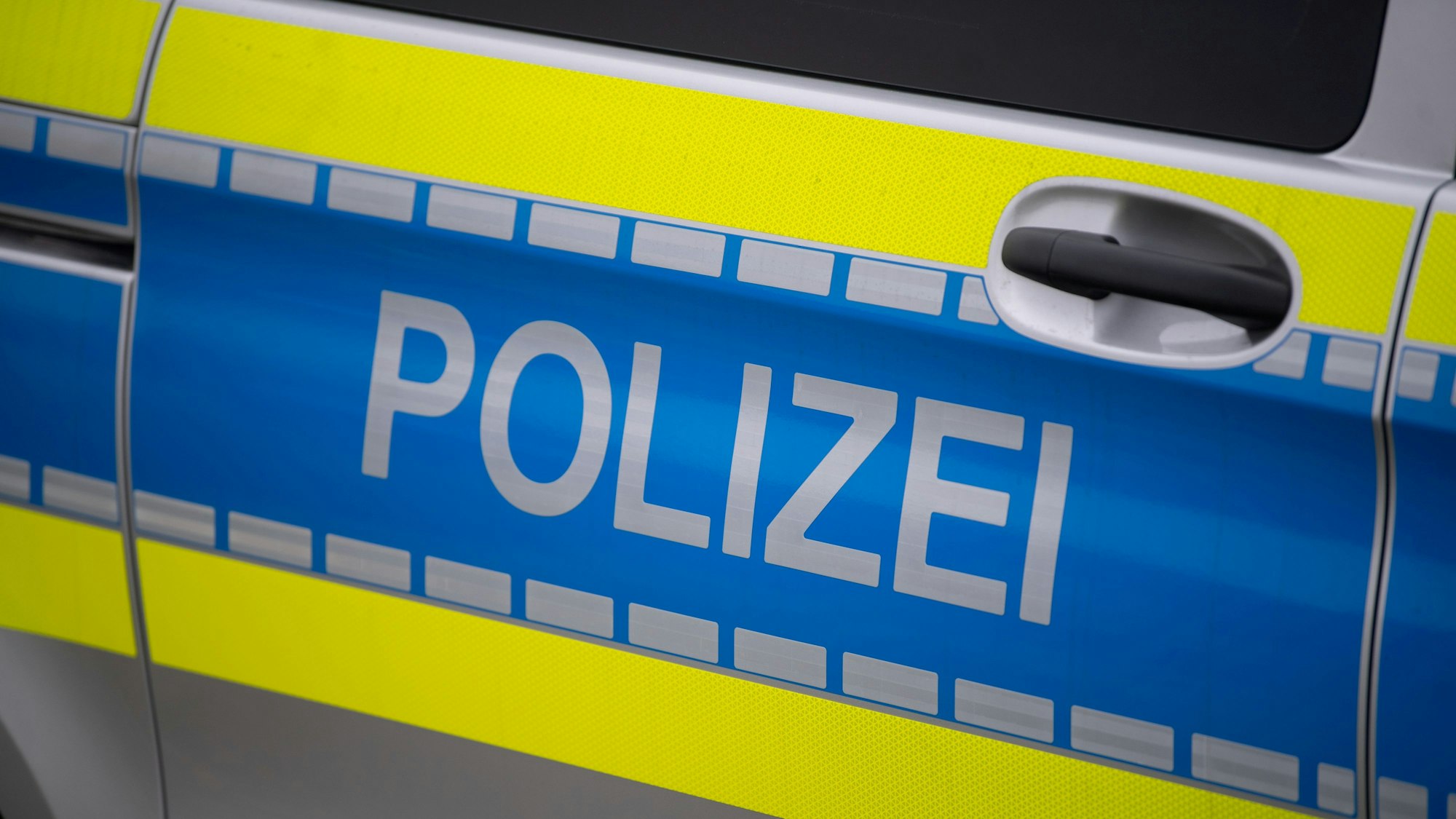 Auf dem Foto ist die Tür eines Polizeiwagens zu sehen, darauf die Aufschrift „Polizei“.