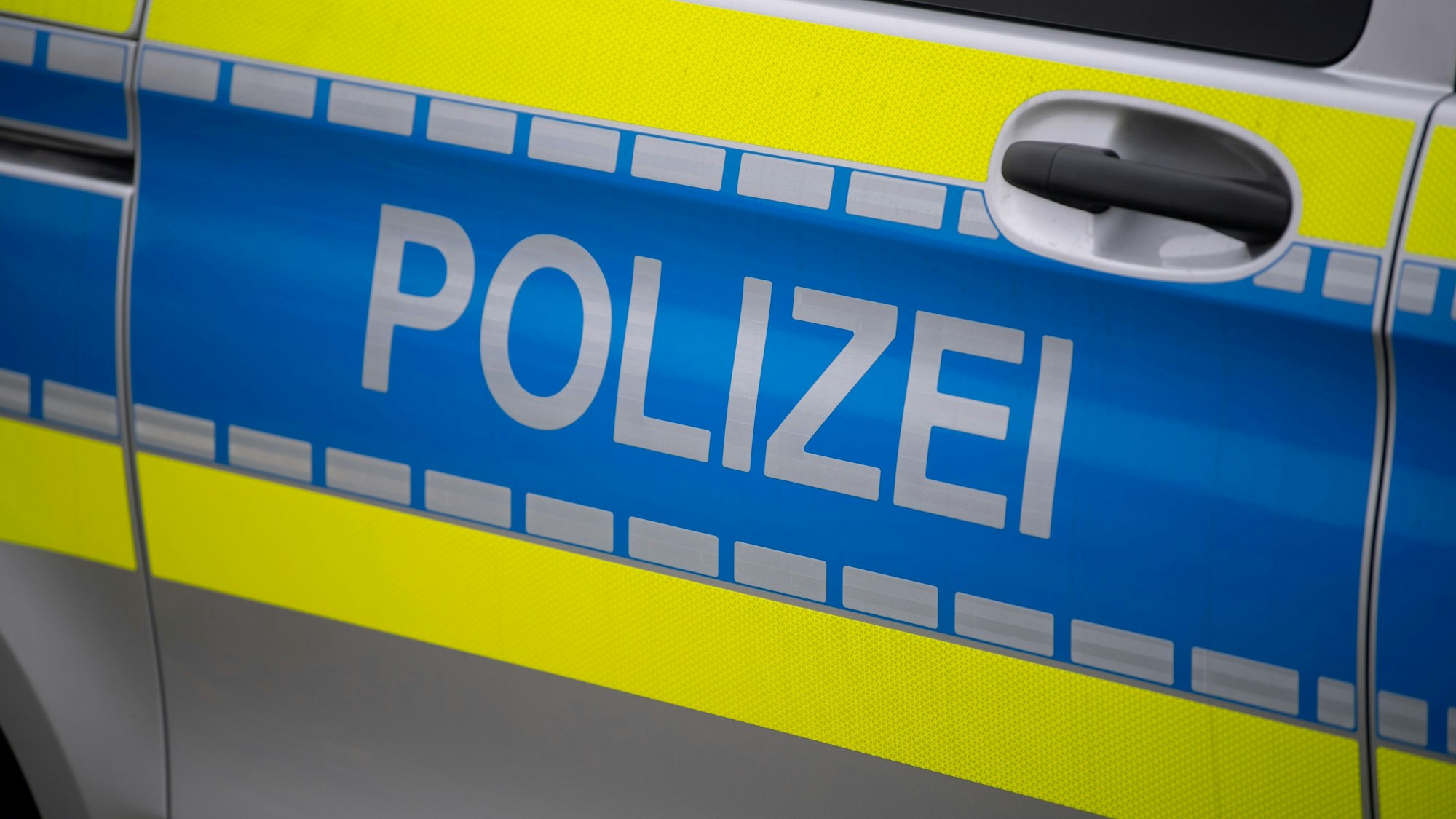 Das Symbolbild zeigt die Tür eines Streifenwagens. Die Aufschrift Polizei ist zu lesen.
