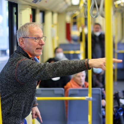 KVB-Mobilitätstrainer Markus Schönbein steht in einer Bahn und erklärt einer Gruppe, worauf sie achten sollen.