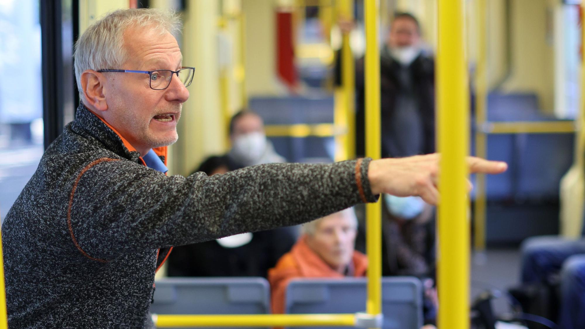 KVB-Mobilitätstrainer Markus Schönbein steht in einer Bahn und erklärt einer Gruppe, worauf sie achten sollen.