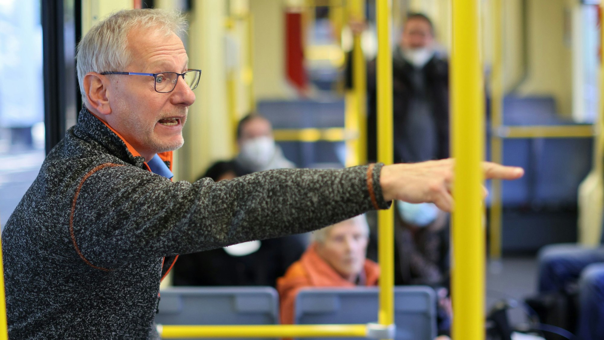 KVB-Mobilitätstrainer Markus Schönbein steht in einer Bahn und erklärt einer Gruppe, worauf sie achten sollen.