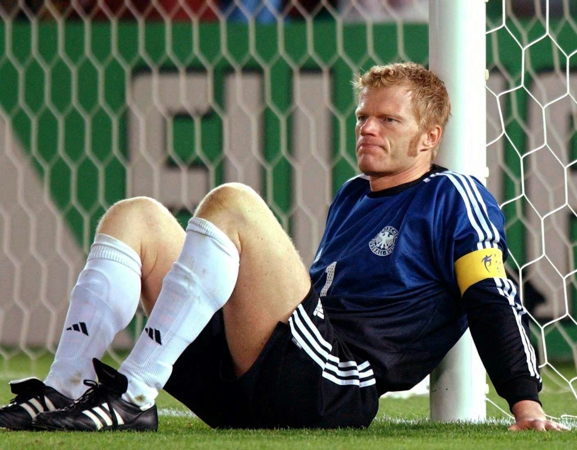 Oliver Kahn sitzt bei Spielende deprimiert am Pfosten.