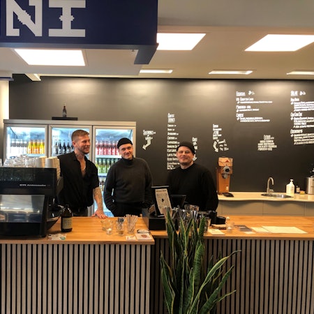 Drei junge Männer hinter einer Bartheke