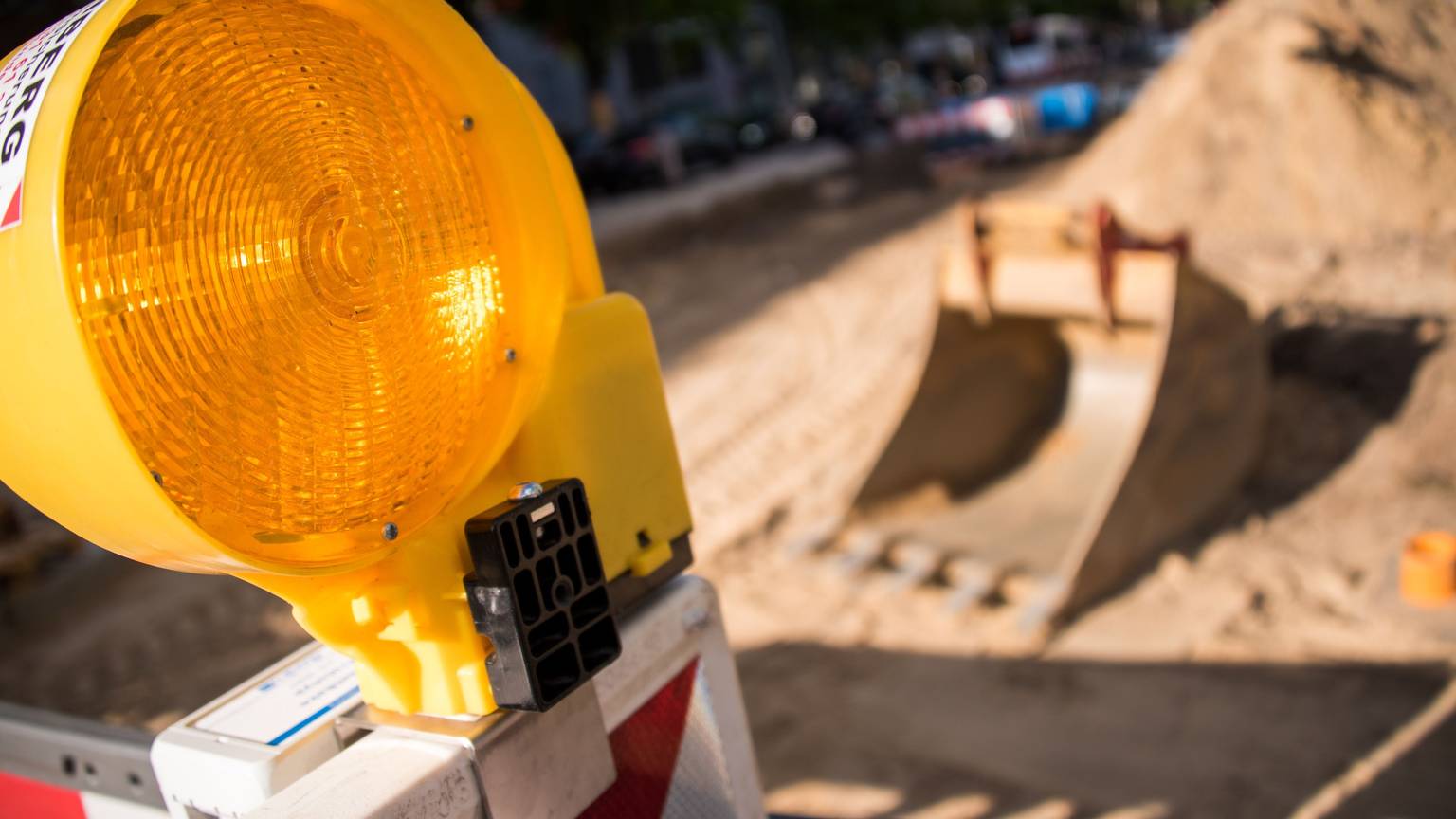 Eine Warnlampe steht an der Absperrung einer Baustelle