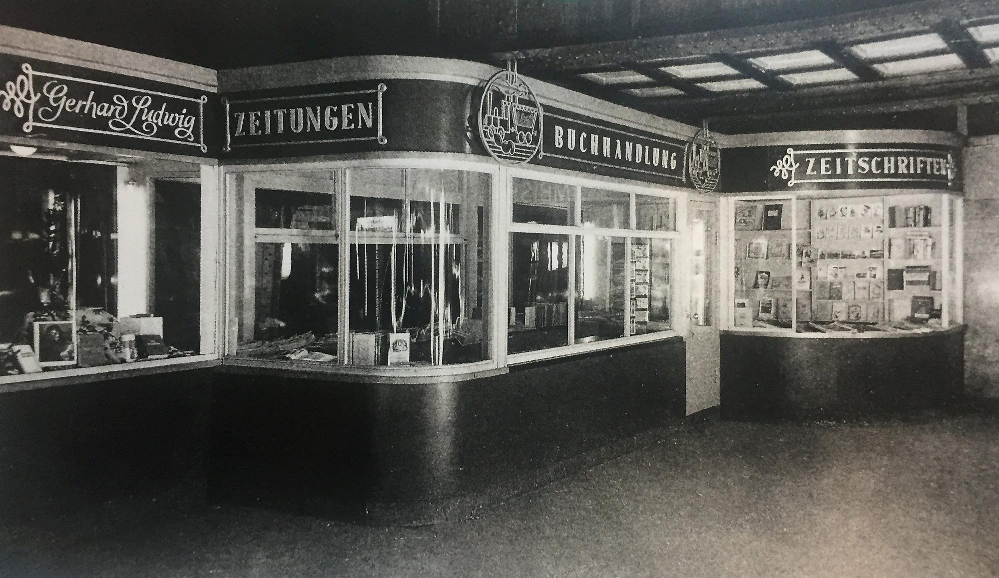Das Schwarz-Weiß-Foto zeigt die Buchhandlung im Jahr 1948, die Schaufenster sind geschwungen, darüber stehen der Name Gerhard Ludwig und die Wörter Zeitungen, Buchhandlung und Zeitschriften.