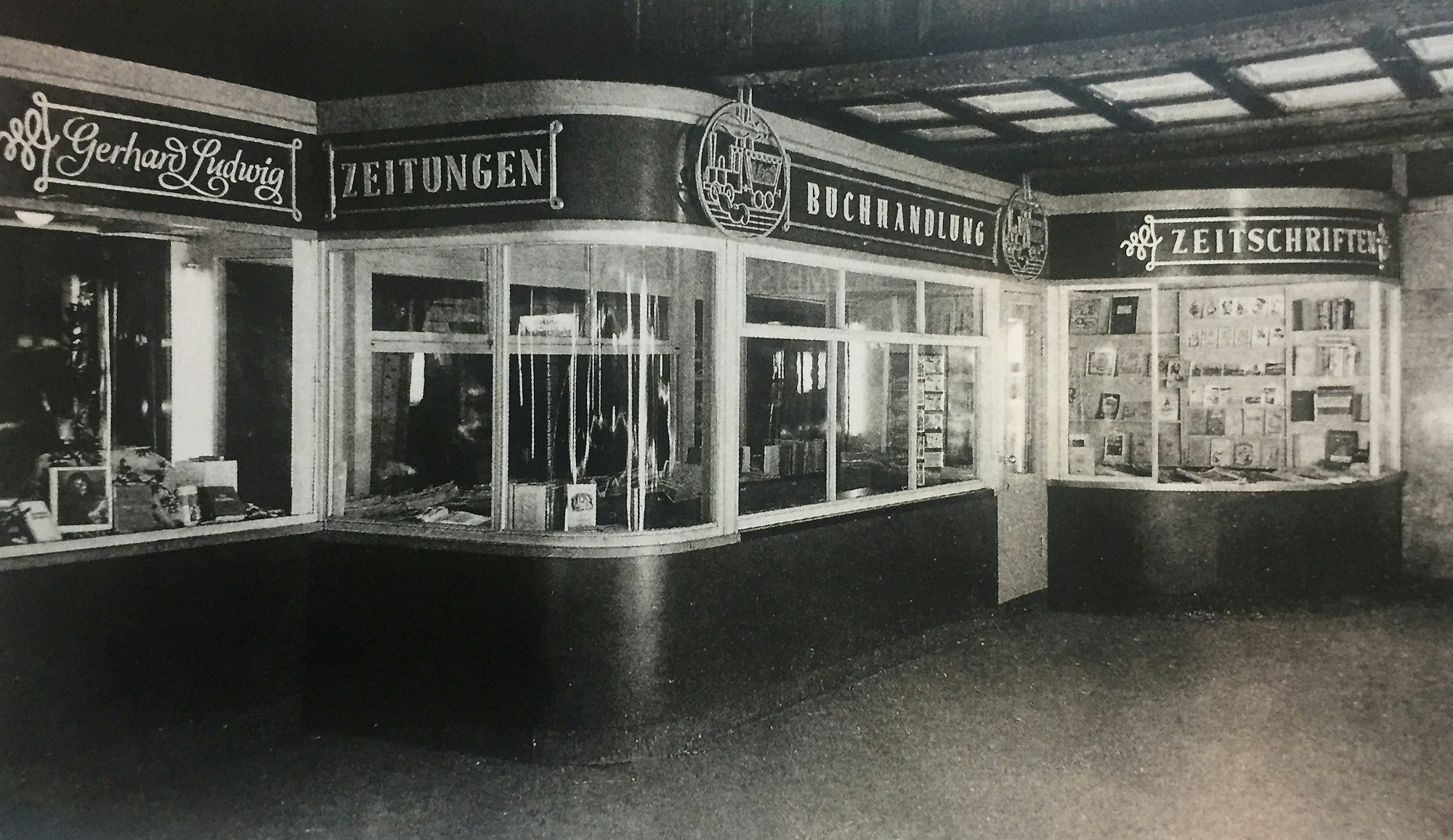 Das Schwarz-Weiß-Foto zeigt die Buchhandlung im Jahr 1948, die Schaufenster sind geschwungen, darüber stehen der Name Gerhard Ludwig und die Wörter Zeitungen, Buchhandlung und Zeitschriften.