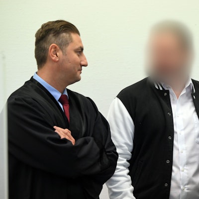 Der Angeklagte steht zwischen seinen Anwälten Mutlu Günal und Martin Bücher.