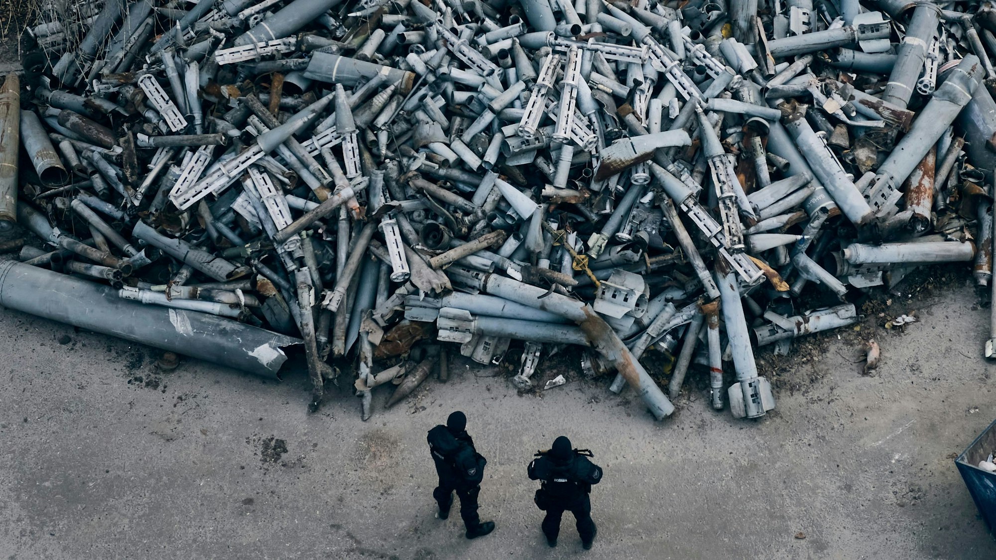 Polizisten betrachten eingesammelten Fragmente, die nach ukrainischen Angaben von russichen Raketen stammen, die in Charkiw eingeschlagen sind.