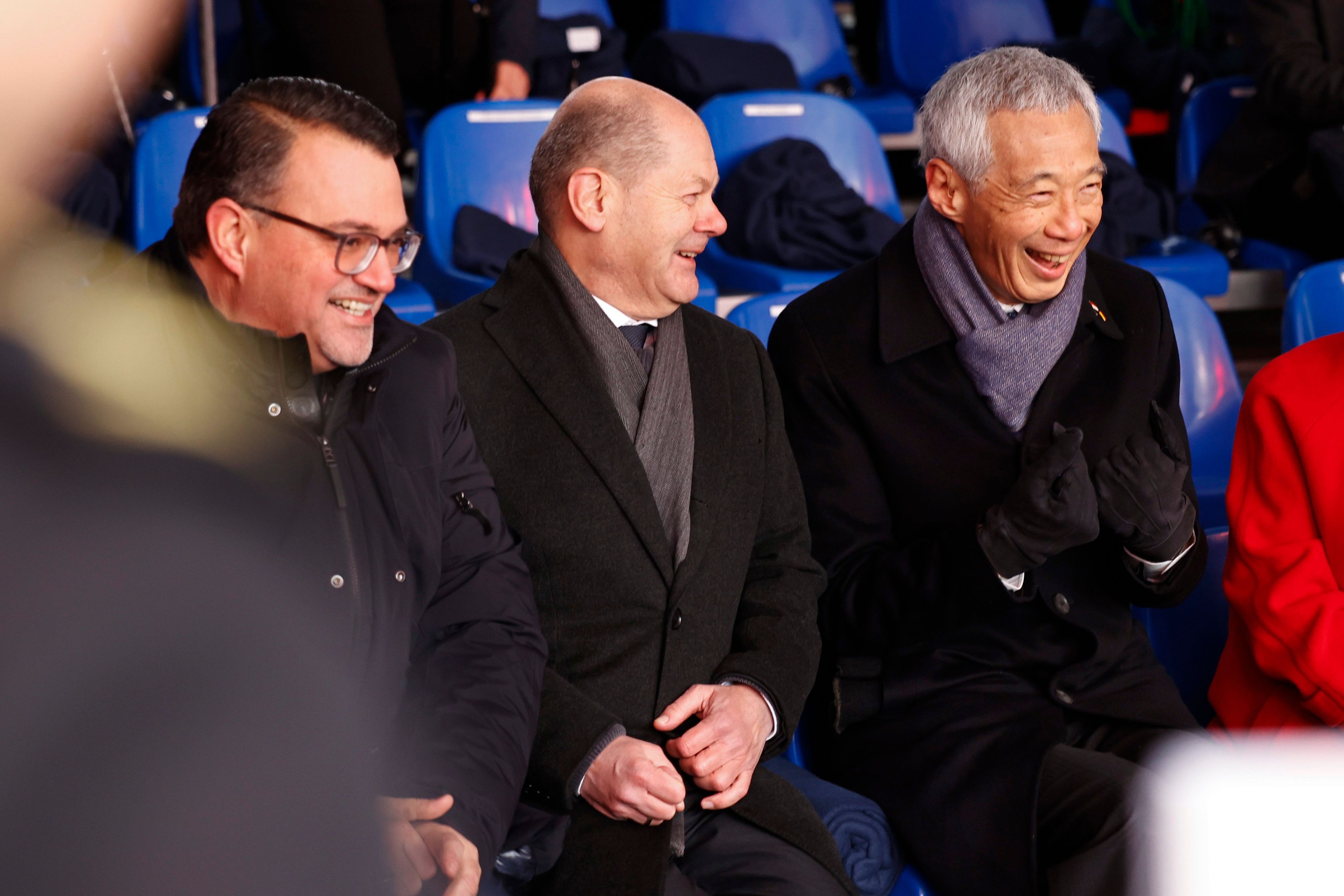Oliver Burkhard, CEO von thyssenkrupp Marine Systems, Bundeskanzler Olaf Scholz und der singapurische Premierminister Lee Hsien Loong (v.l.n.r.) lachen während der Taufzeremonie.