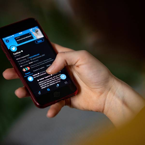 Eine Person hält ein Smartphone auf dem die Twitter-App zu sehen ist.