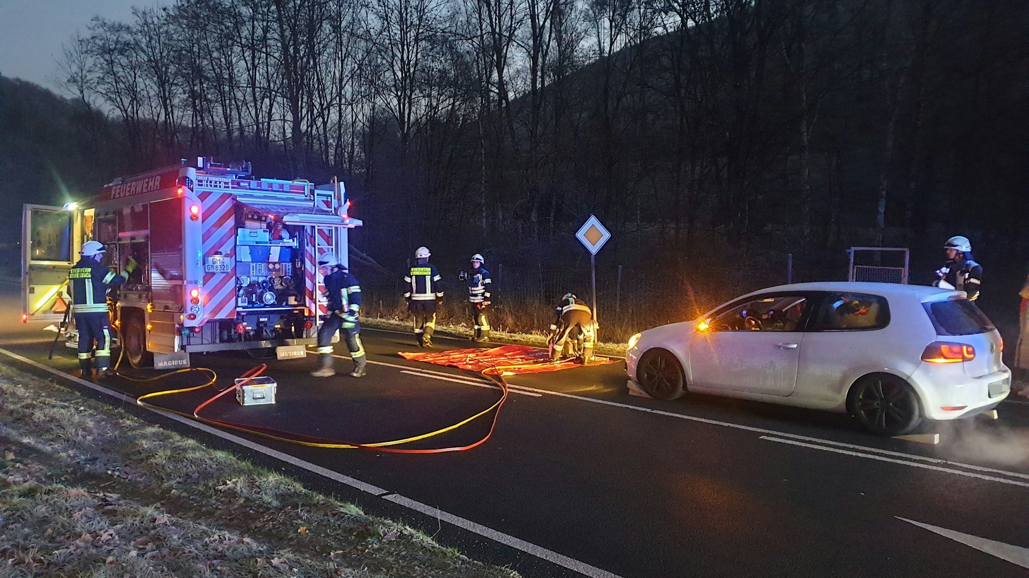 Ein Auto steht auf der Straße, davor ein Feuerwehrauto.
